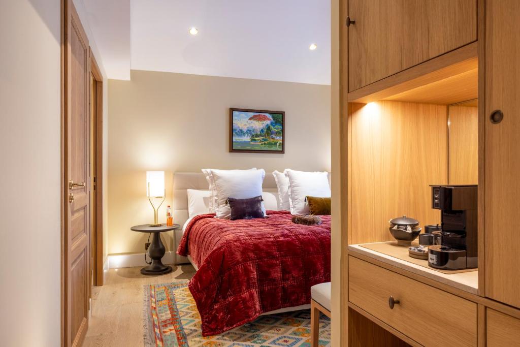 um quarto com uma cama com uma colcha vermelha em Hotel La Mère Germaine em Châteauneuf-du-Pape