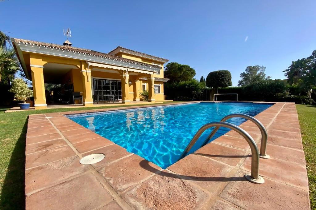 a swimming pool in front of a house at Villa El Higueral in Marbella