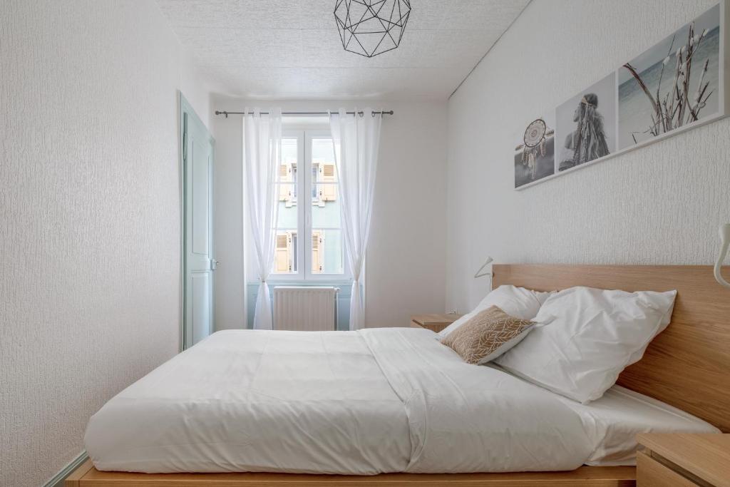 - une chambre avec un lit doté de draps blancs et une fenêtre dans l'établissement Travel Homes - Le Carls: agréable, mignon, moderne, à Mulhouse