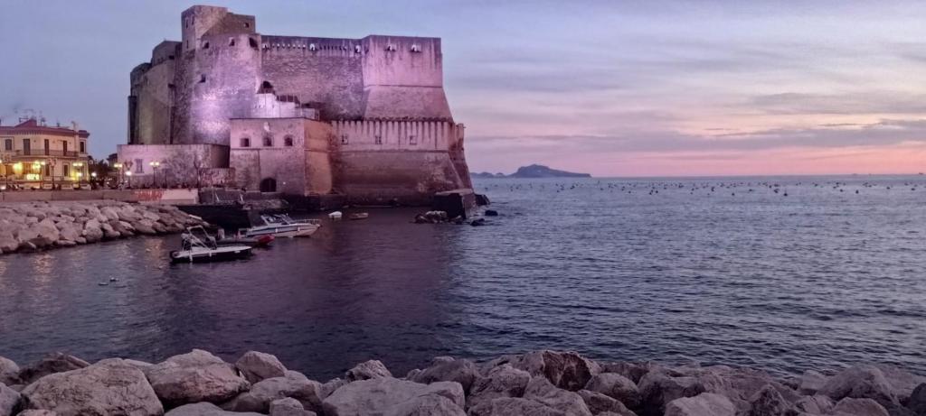 a castle sitting in the water next to the ocean at La Stanza a parte in Naples