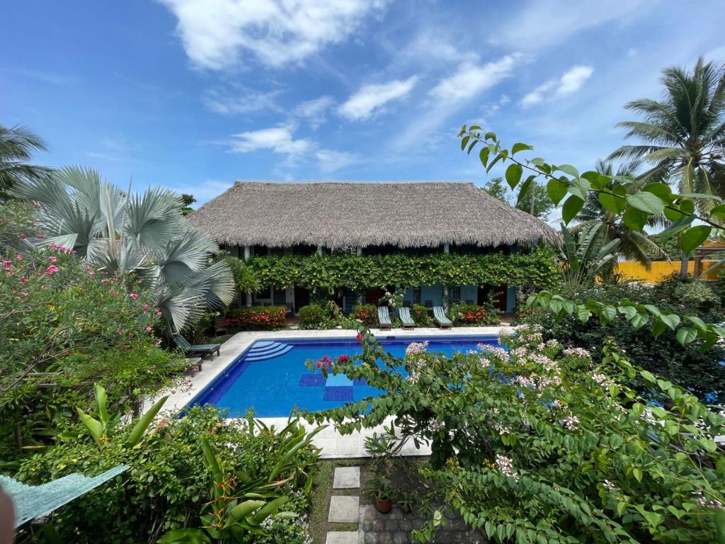 a villa with a swimming pool in a garden at Hotel Atelie del Mar in Monterrico