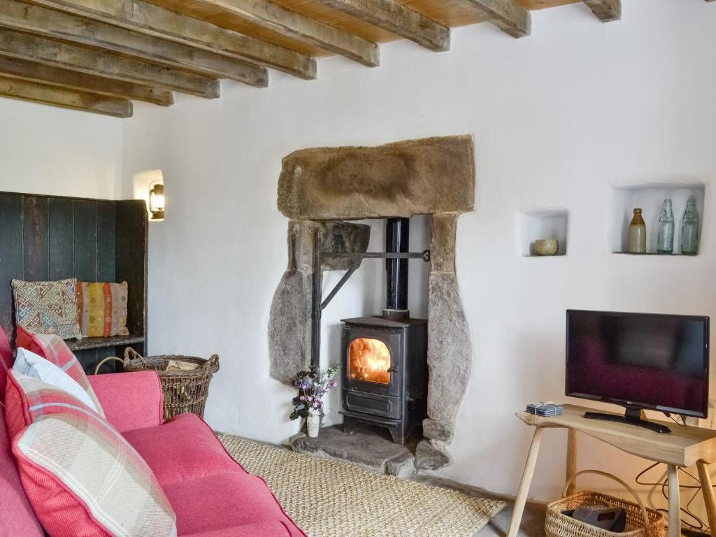 a living room with a wood stove in a room at Springlea Cottage in Dean