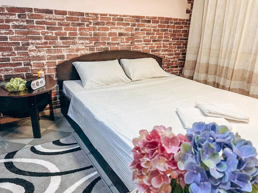 um quarto com uma cama e uma parede de tijolos em Guest House on Saksahanskoho Street em Kiev