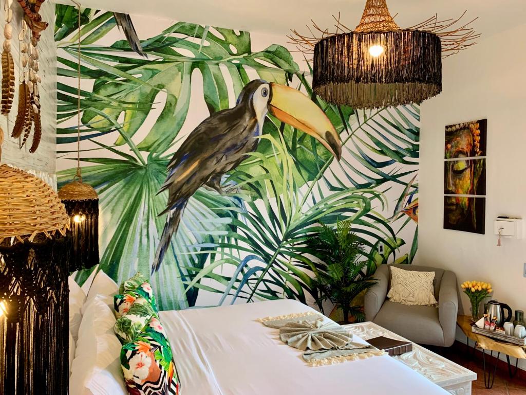 ein Schlafzimmer mit einem Bild eines Vogels an der Wand in der Unterkunft Castillo Tulum in Tulum