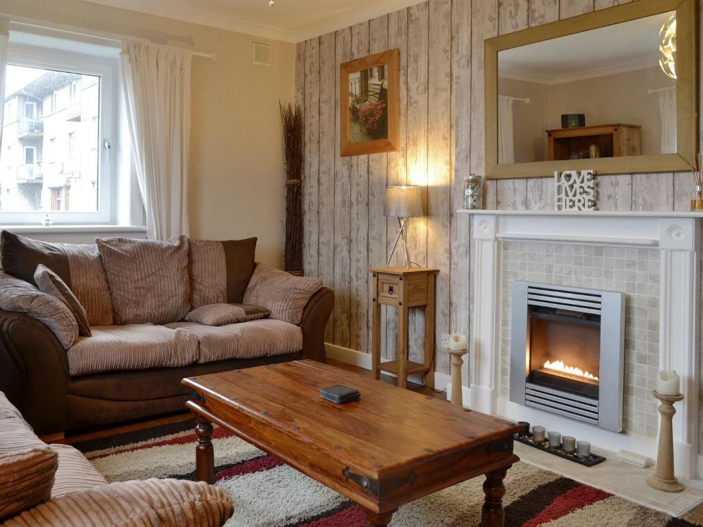 a living room with a couch and a fireplace at Queens Buildings in Tayport