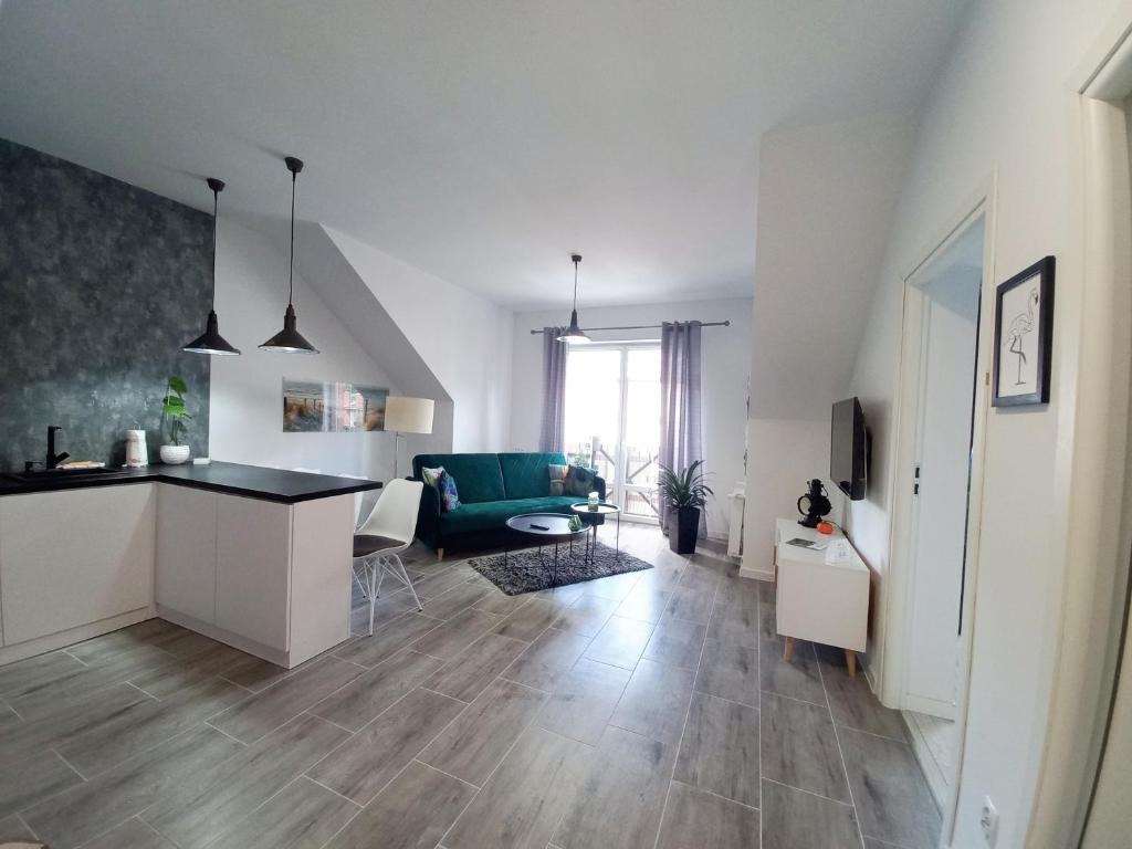 a living room with a kitchen and a living room with a couch at Apartament nad Jeziorem in Olecko