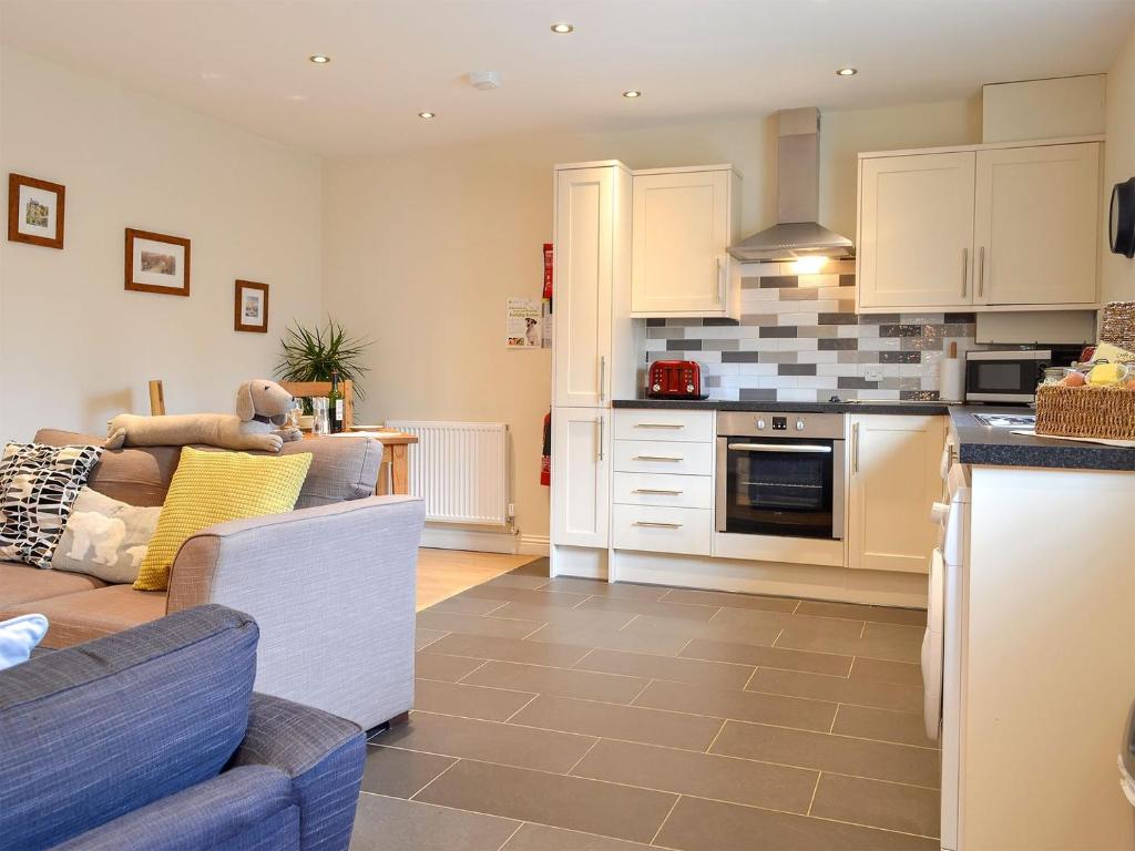 a living room with a couch and a kitchen at Croft Cottage 1 - Uk10587 in Stillington