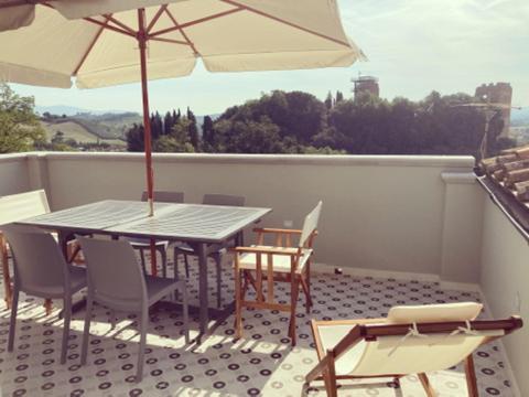 eine Terrasse mit einem Tisch, Stühlen und einem Sonnenschirm in der Unterkunft Castruccio 4 - casa con vista sulla via Francigena in Fucecchio