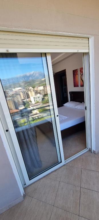 una camera da letto con una grande porta scorrevole in vetro di Luis Penthouse a Berat