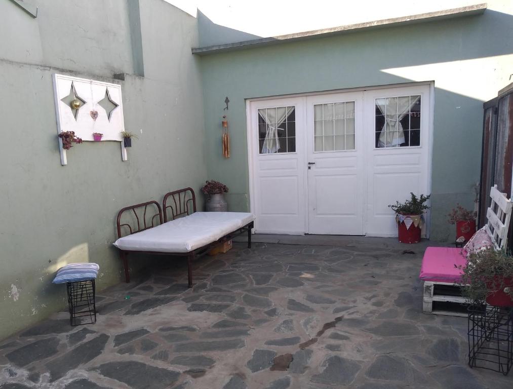 a patio with a white door and a bench at Aquí te Espero in Tandil