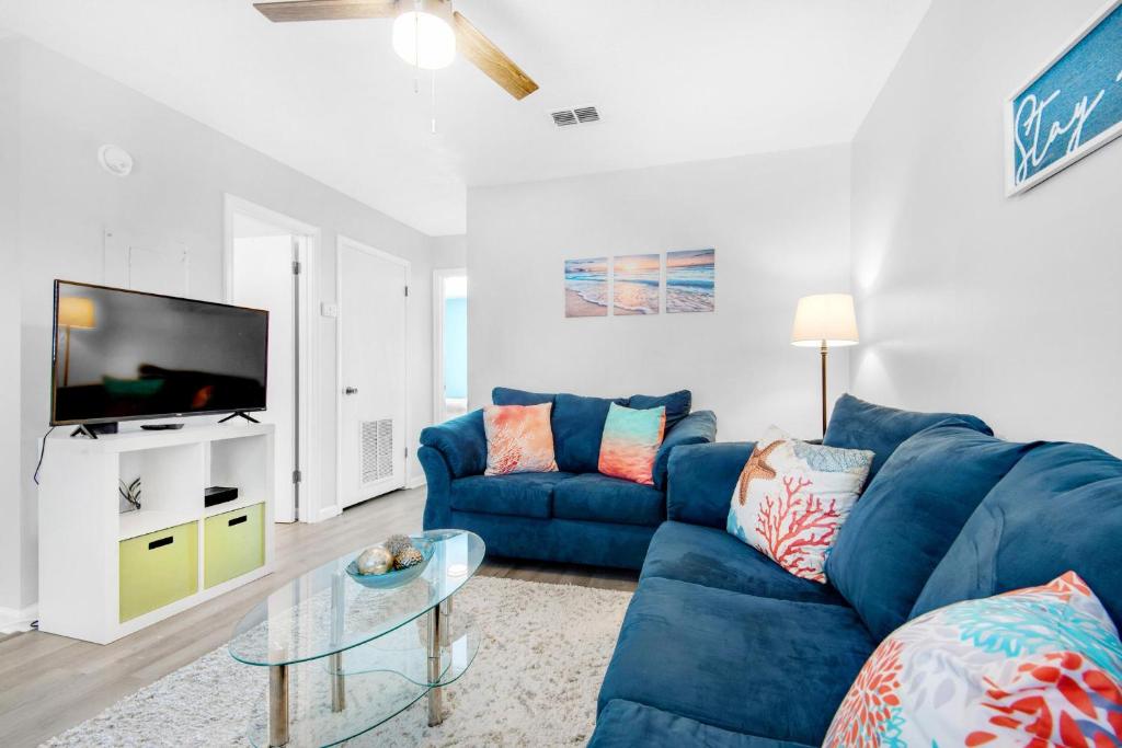 a living room with a blue couch and a tv at Sand Castles West II G6- NEW in Panama City Beach