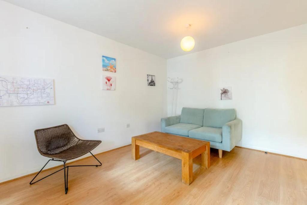 a living room with a blue couch and a chair at Spacious 1 Bed apartment near Shoreditch Park in London