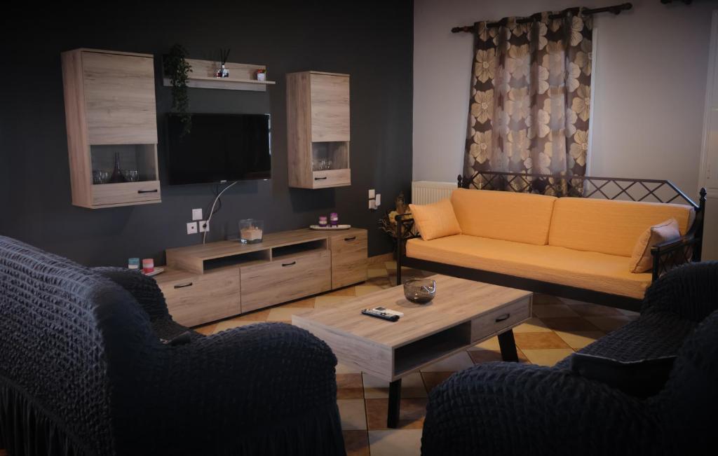 - un salon avec un canapé jaune et une télévision dans l'établissement Vretti's apartment, à Cythère
