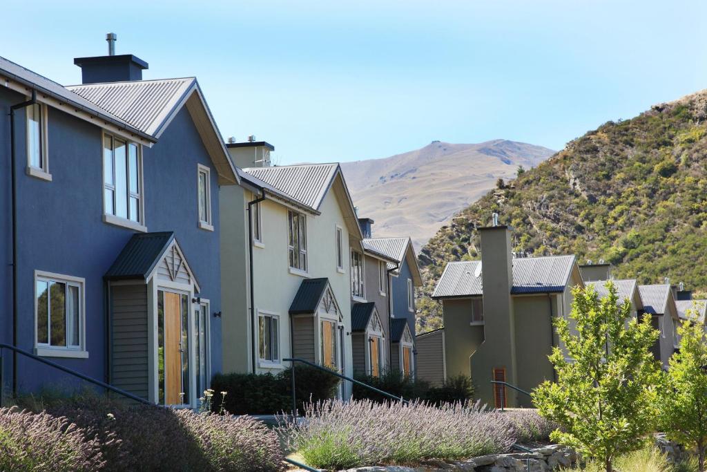 a row of houses with mountains in the background at Arrowfield Apartments in Arrowtown