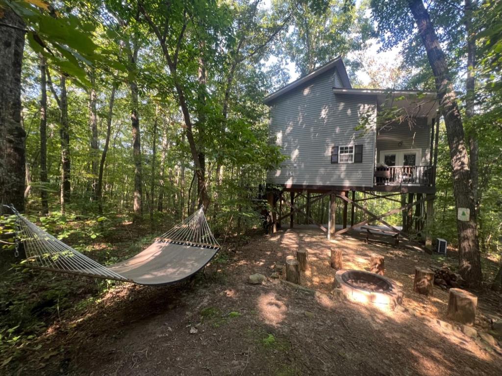 a hammock in front of a house in the woods at Serenity Escape Treehouse on 14 acres near Little River Canyon in Fort Payne