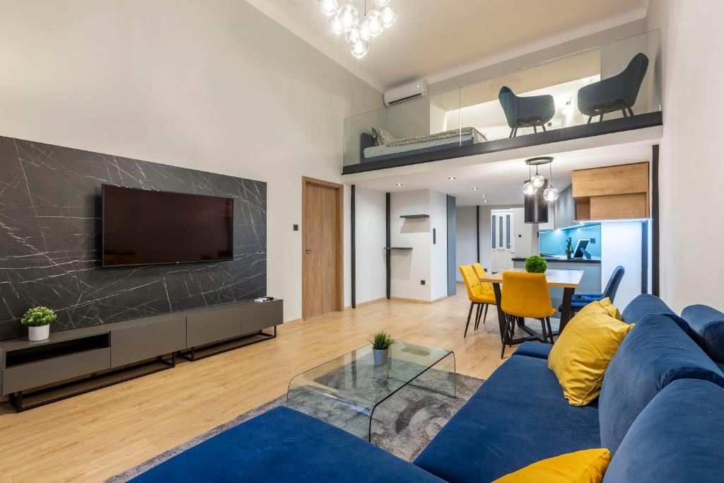 a living room with a blue couch and a tv at Exclusive New York Residence in the Heart of Budapest in Budapest