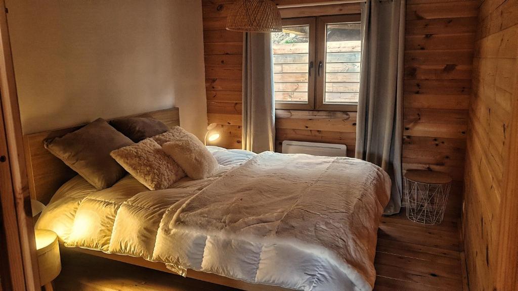 1 dormitorio con 1 cama en una habitación con ventana en Vue imprenable et jacuzzi 4 Etoiles, en Bagnères-de-Bigorre