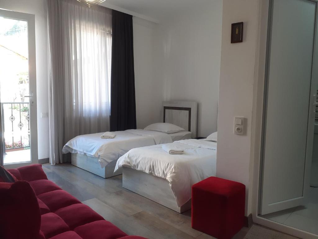 a hotel room with two beds and a red couch at Family house in Borjomi