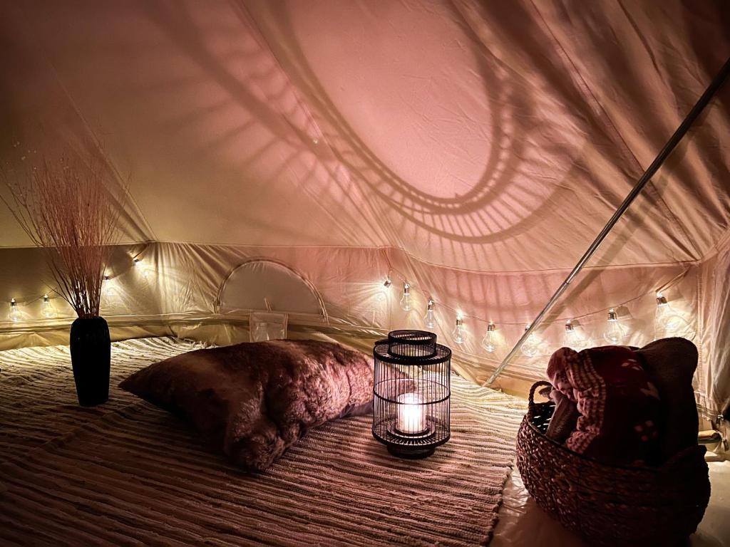 a bedroom with a tent with a candle on a bed at Lux Glamping, Lammas 