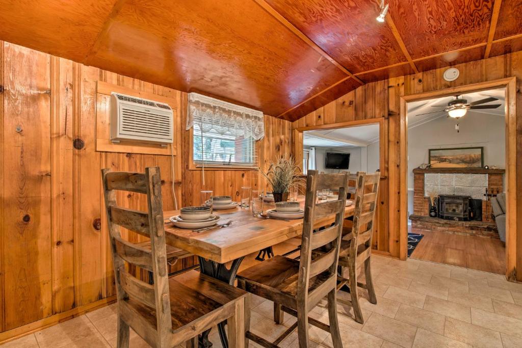 Un comedor con mesa y sillas de madera. en Plum Creek Retreat with Beach near Johnson Lake, 