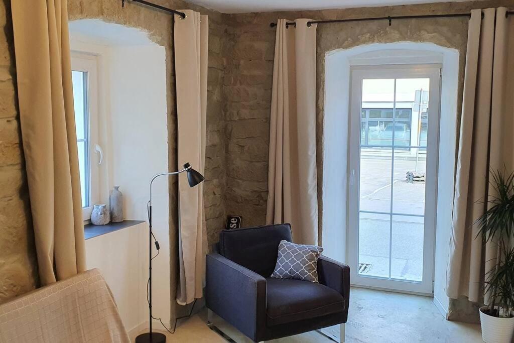 a living room with a chair in front of a door at Apartment Steinwald in Oberndorf in Oberndorf