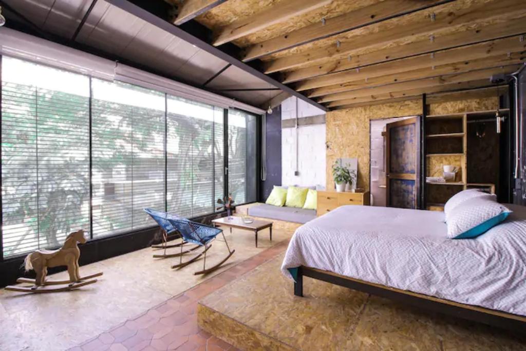 a bedroom with a large bed and a large window at Santa Teresita Loft in Cali