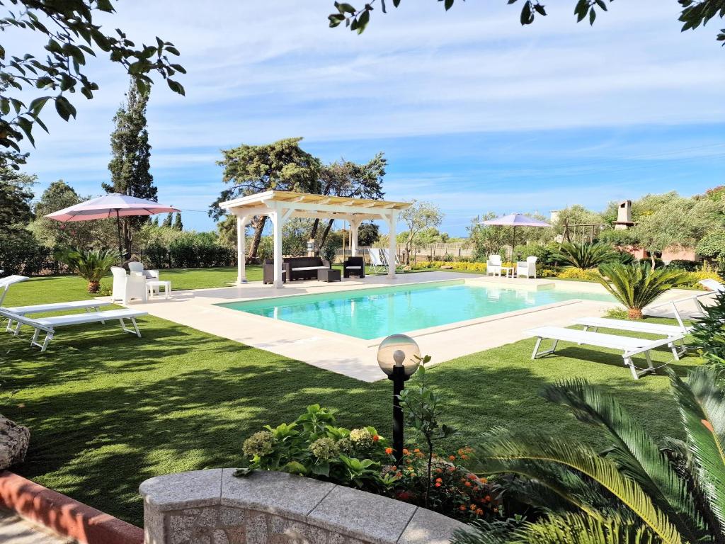 a pool in a yard with a gazebo at Antico Casolare Sorso-Tourist Rental in Sorso