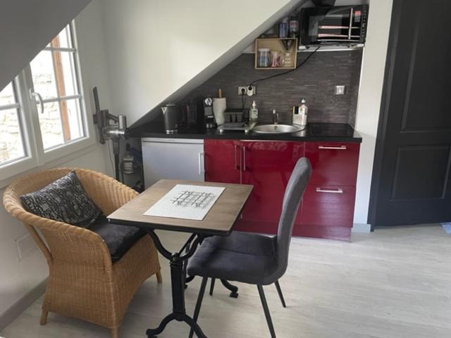 - une cuisine avec une table, 2 chaises et un évier dans l'établissement Studio centre ville, à Compiègne