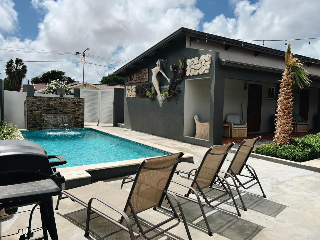 een patio met stoelen en een zwembad bij Aruba Bliss Condos in Oranjestad