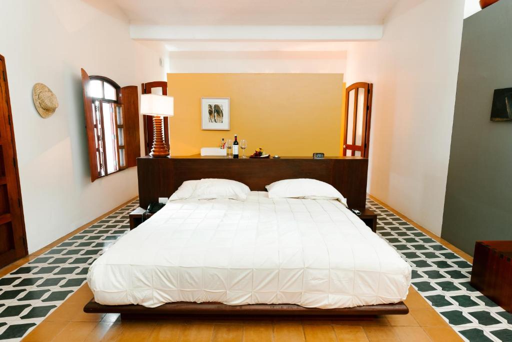 a bedroom with a large white bed in a room at Hotel Azul de Oaxaca in Oaxaca City