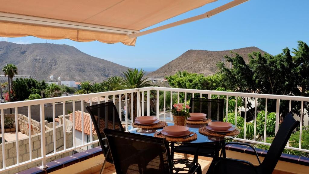 a table on a balcony with mountains in the background at Atico Carlota- Feel Canarias ! in Chayofa