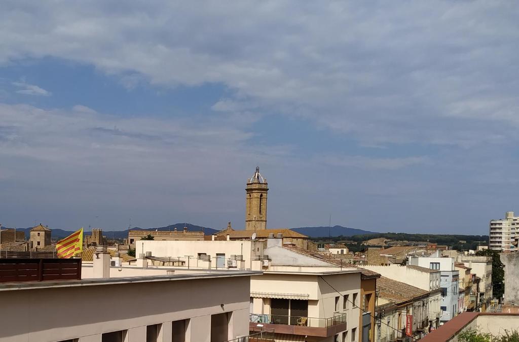 Blick auf eine Stadt mit einem Uhrturm in der Unterkunft Casa cèntrica a La Bisbal d'Empordà in La Bisbal