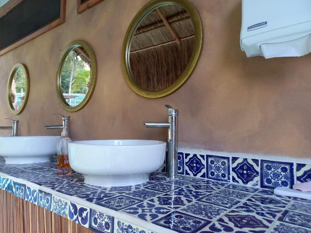 a bathroom with two sinks and two mirrors at Pepos Xul-Ha in Xul-Ha
