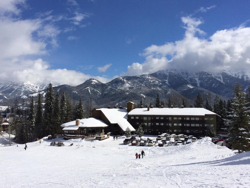 a ski lodge in the snow in front of a mountain at The Griz Inn by Park Vacation Management in Fernie