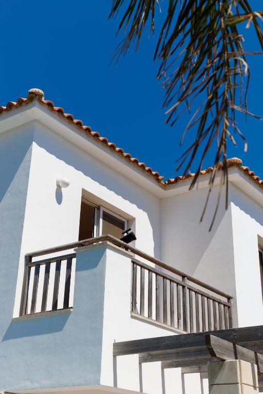 Casa blanca con balcón y palmera en Luxury Villa en Ayia Napa