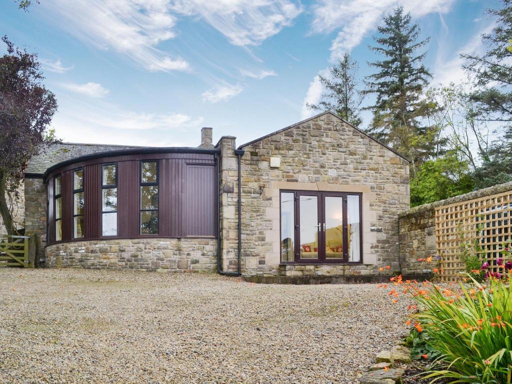 an exterior view of a stone house with large windows at The Gingang in Hexham