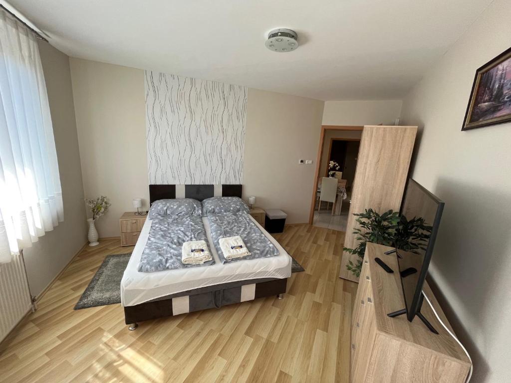 Schlafzimmer mit einem Bett und Holzboden in der Unterkunft RelaxAp Zalakaros in Zalakaros