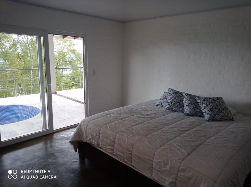a bedroom with a bed and a sliding glass door at Villa las Águilas 1 in Borrero Ayerbe
