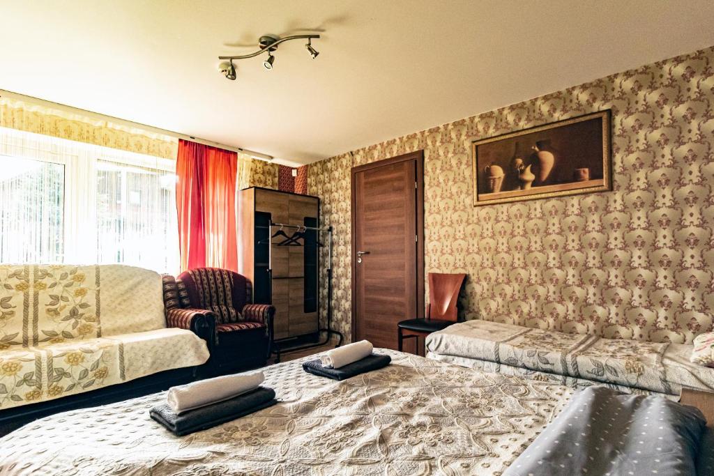 1 dormitorio con 1 cama, 1 sofá y 1 silla en Viešnagė pas Valentiną, en Sužionys