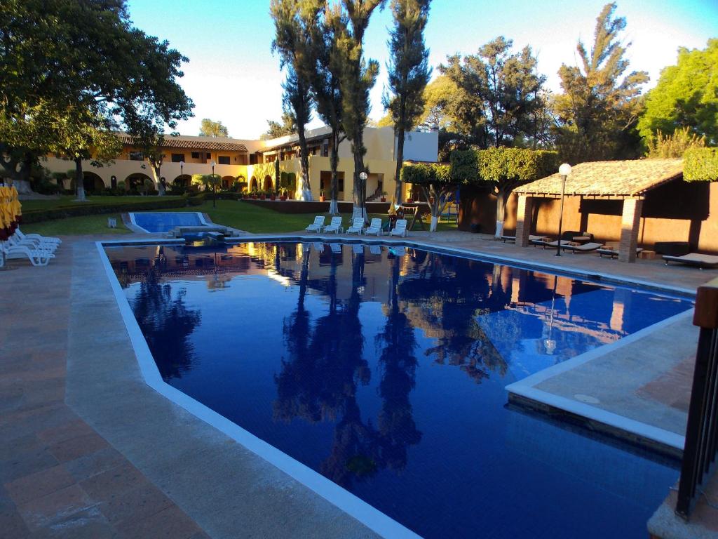 a swimming pool with blue water in a yard at Casa Cantarranas in Tehuacán
