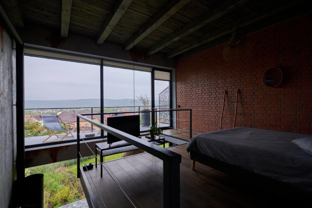 1 dormitorio con 1 cama y balcón con vistas. en Апартаменты True Love с видом на горы en Úzhgorod
