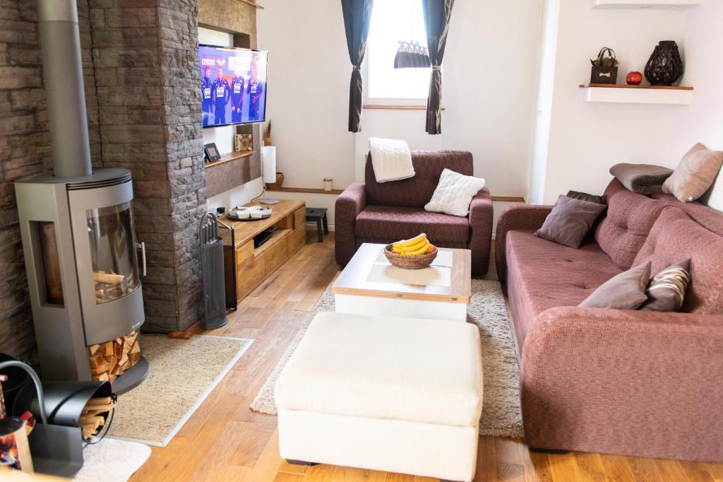 a living room with a couch and a fireplace at Apartman Ena in Vlasic