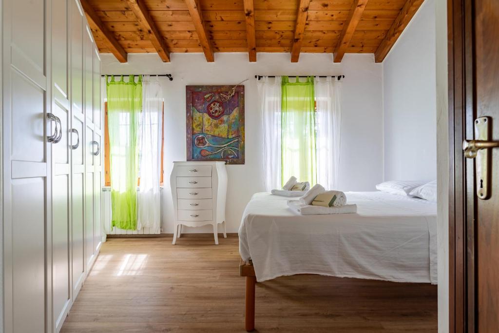 um quarto com uma cama, uma cómoda e janelas em Appartamento Al Vigneto em Montorio Veronese