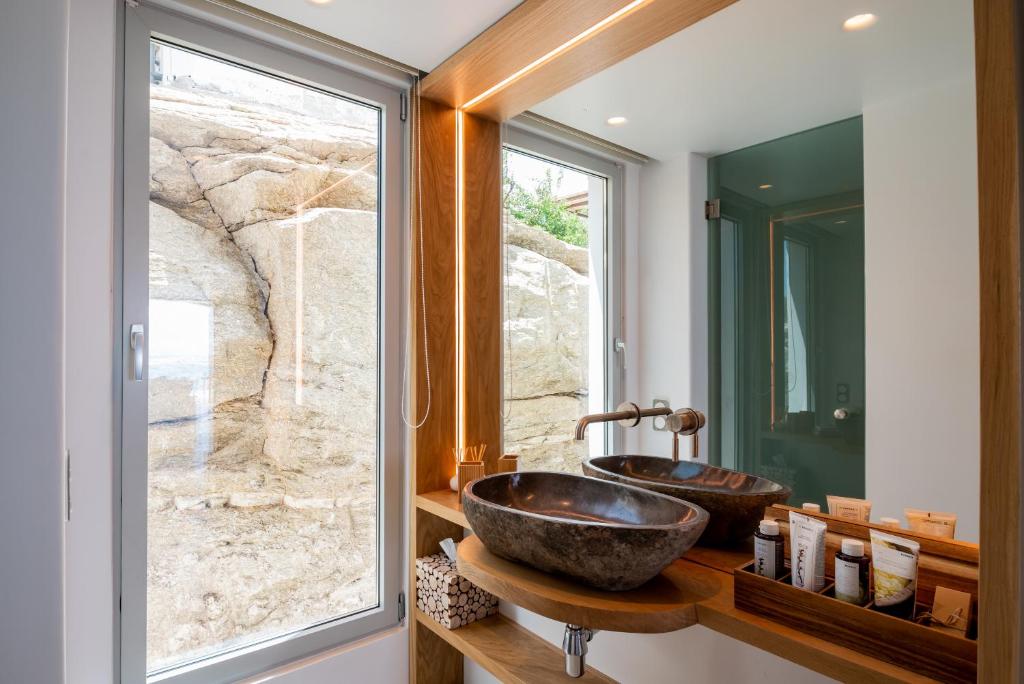 uma casa de banho com um lavatório de pedra e uma janela em Villa Nima em Klouvas