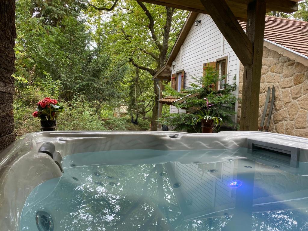 a hot tub in front of a house at Mesebeli Vendégház in Kismaros