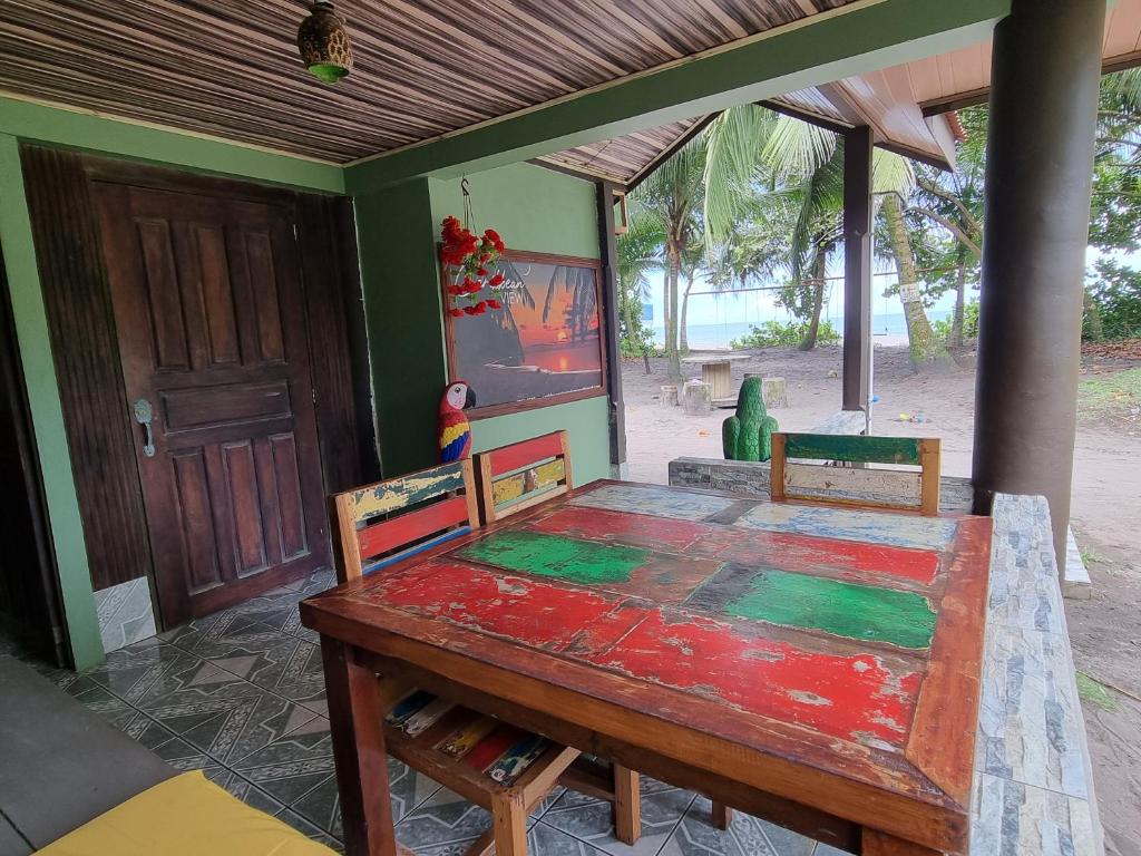 een eetkamer met een tafel en een deur bij Caribbean View House in Tortuguero