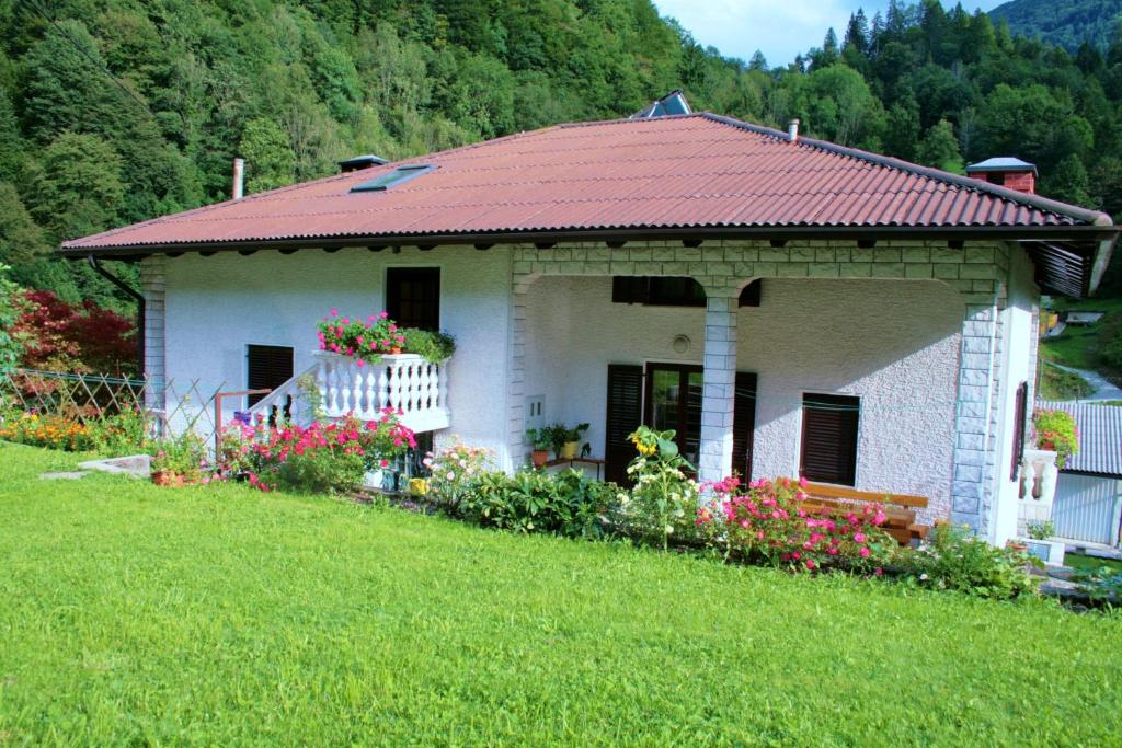 a small white house with a red roof at Rooms with shared kitchen Zver, great for hikers in Hudajužna