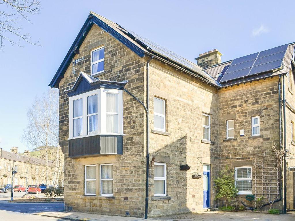 an old brick building with solar panels on it at Lyndale House in Pateley Bridge