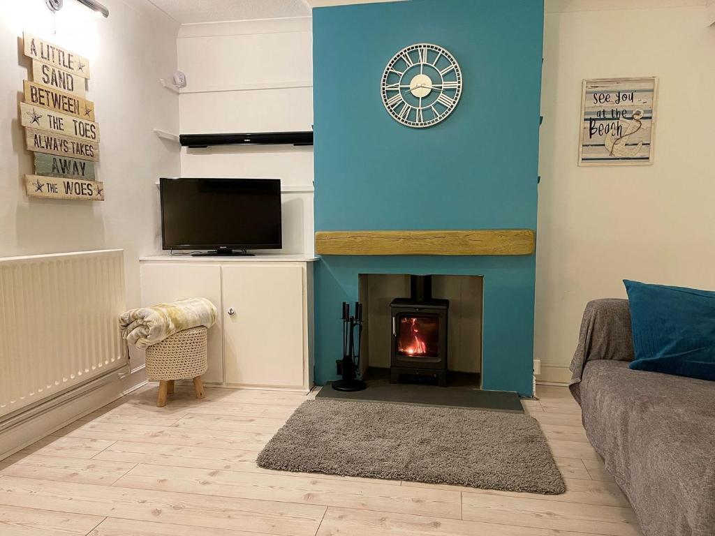 a living room with a fireplace and a tv at Beach House in Pakefield