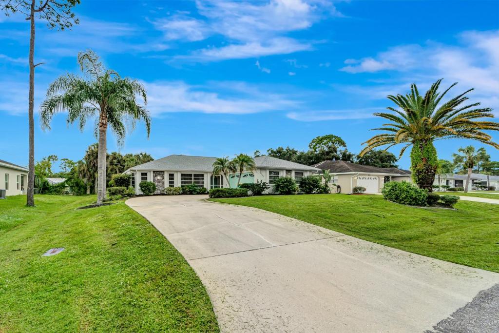 a driveway with palm trees in front of a house at Tropical Oasis in Port Charlotte